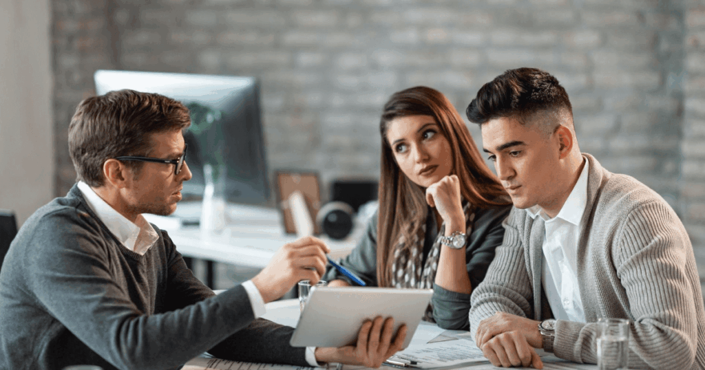 Tres personas reunidas en una oficina