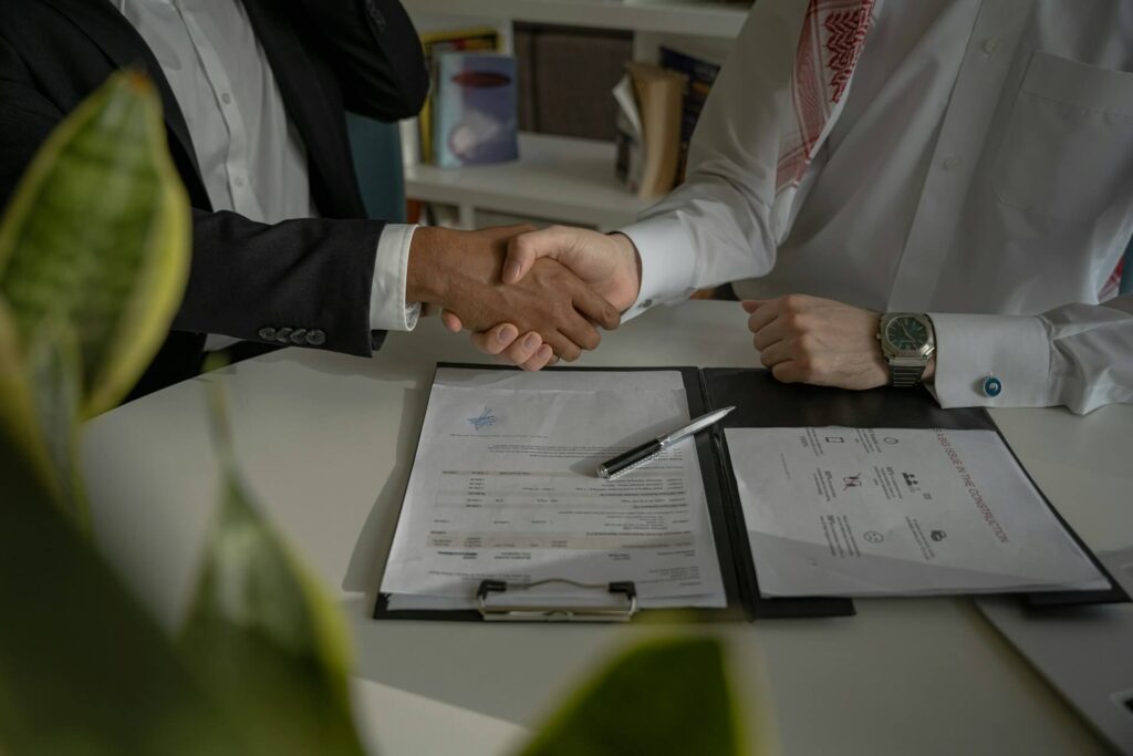 Dos personas estrechándose la mano en un escritorio