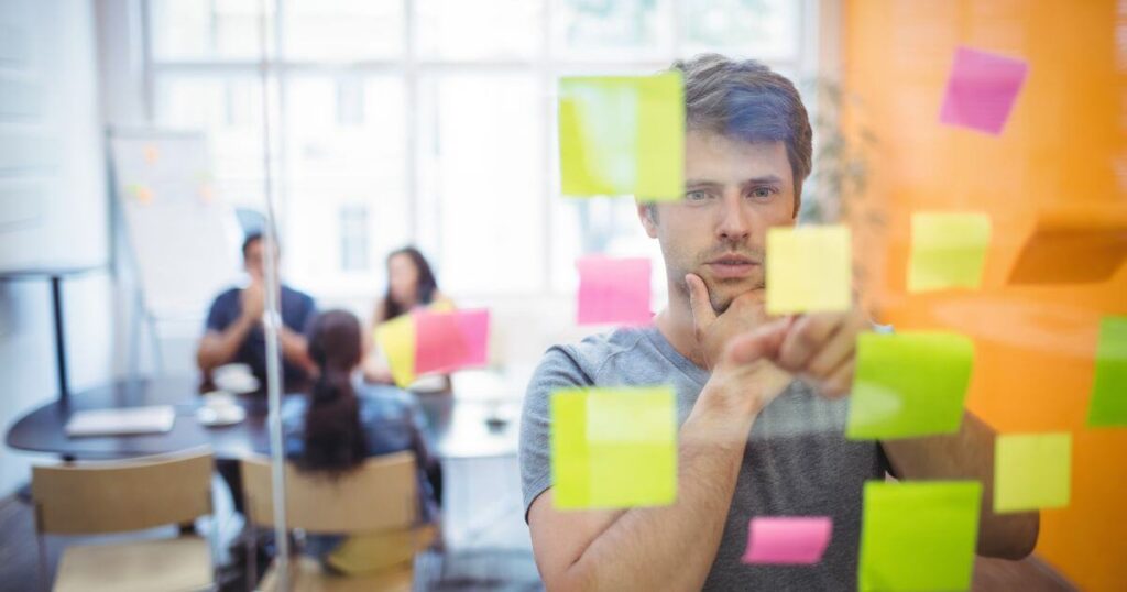 Ejecutivo leyendo notas en post its