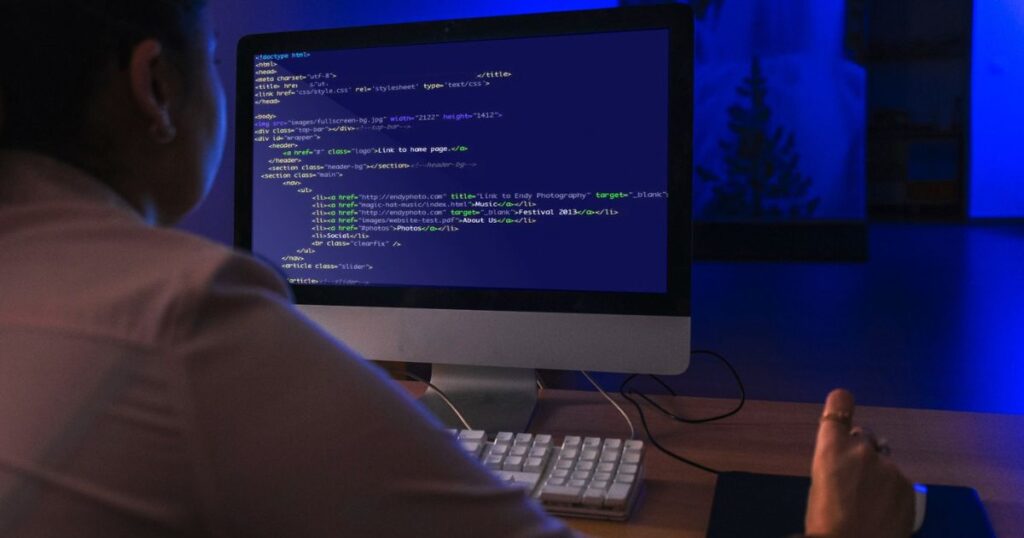 Persona trabajando en código HTML en una computadora